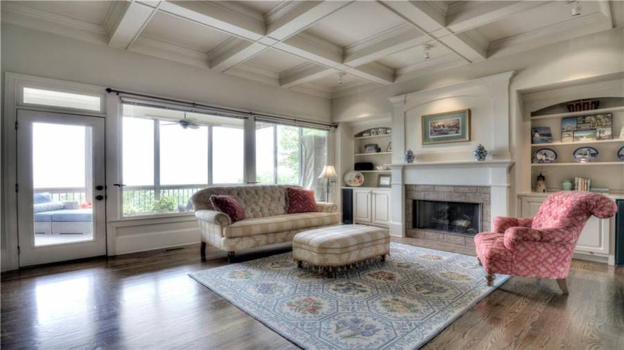 Handsome coffered ceiling with custom stone fireplace flanked by built-in bookshelves.