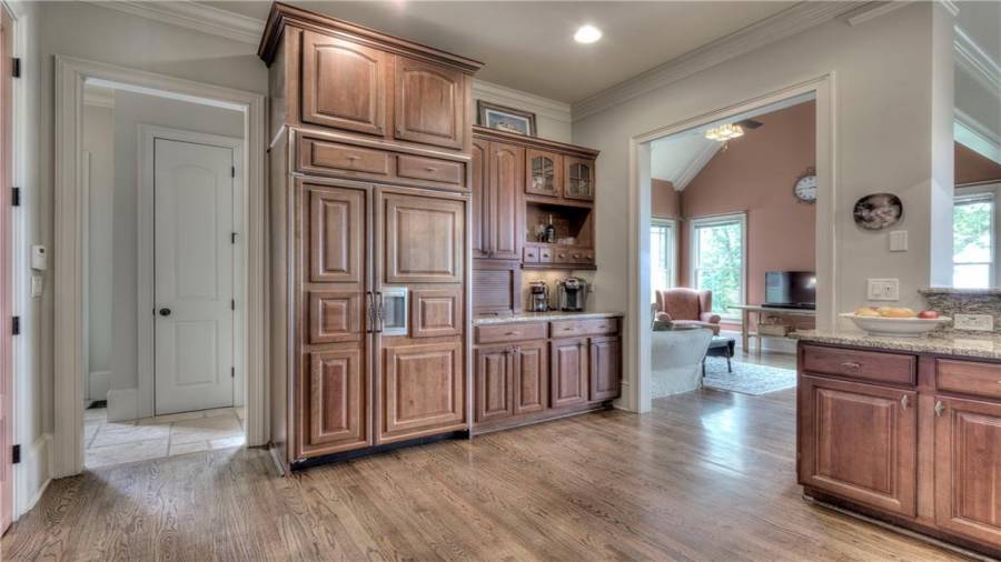 Custom matching wood cabinetry for the refrigerator and coffee and drink bar with its own space.