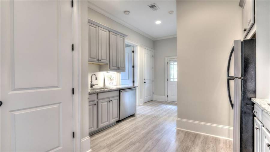 Sink, dishwasher, and under cabinet lighting! Bedroom #5 is to the left after the kitchen. Closed door pictured here leads to lower Terrace Level. Door with windows is an exterior entry from the side of the house. On the right (not showing in this photo) is the door to the full bathroom.