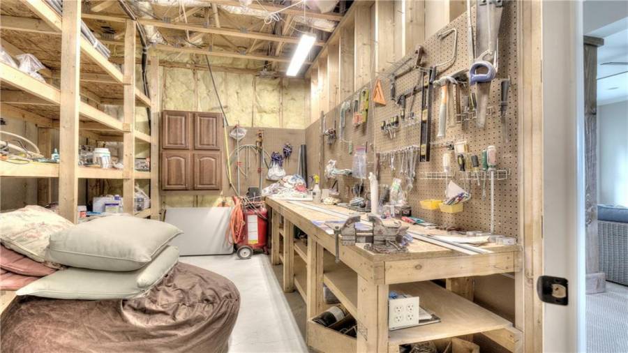 Well-lit Workshop on Terrace Level with built-in shelves, workbench and pegboard