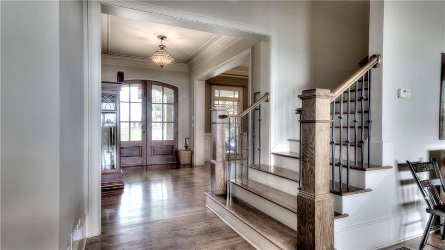 Foyer entry with a beautiful staircase in view.