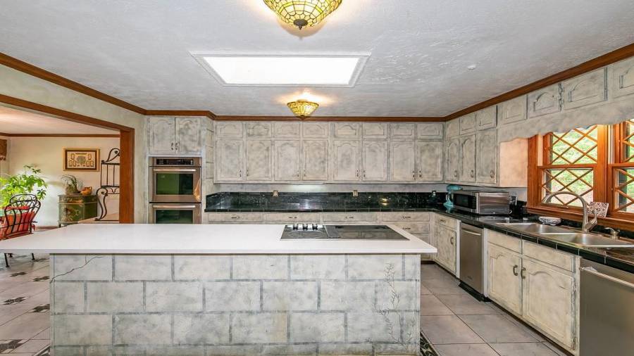 Kitchen with island, granite tile counter, wine cooler and tons of cabinet storage