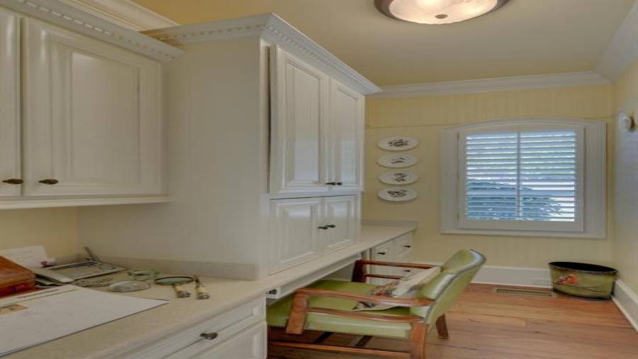 Workroom with desk and lots of cabinetry for filing important papers.