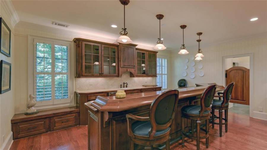 Custom bar in the terrace level features a wet sink, dishwasher, ice maker and microwave.