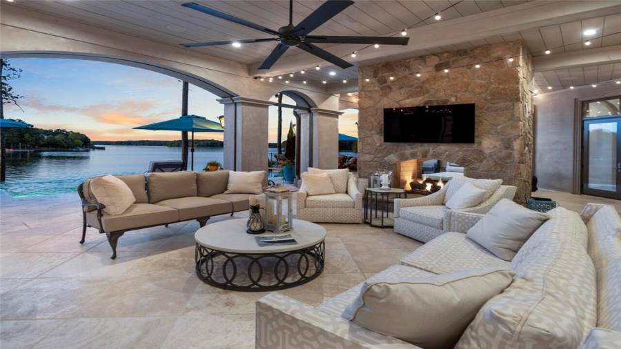 Open the retractible screens and enjoy the view. The covered patio with double sided fireplace is surrounded by views of the lake.