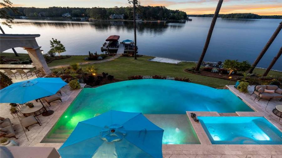 Upstairs outdoor living area overlooks the infinity pool and lakefront entertaining spaces.