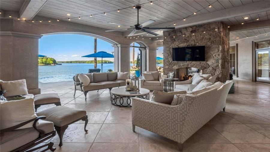 Archways open to views of the lake surround the outdoor living area with double sided fireplace.