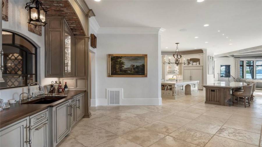 Wood surface bar with brick masonry opens to the kitchen and breakfast room.