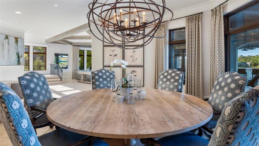 Breakfast room is surrounded by windows overlooking the lake and outdoor living space.