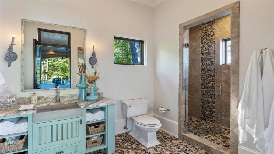 Cabana bathroom accented by river stones opening to the pool bar.