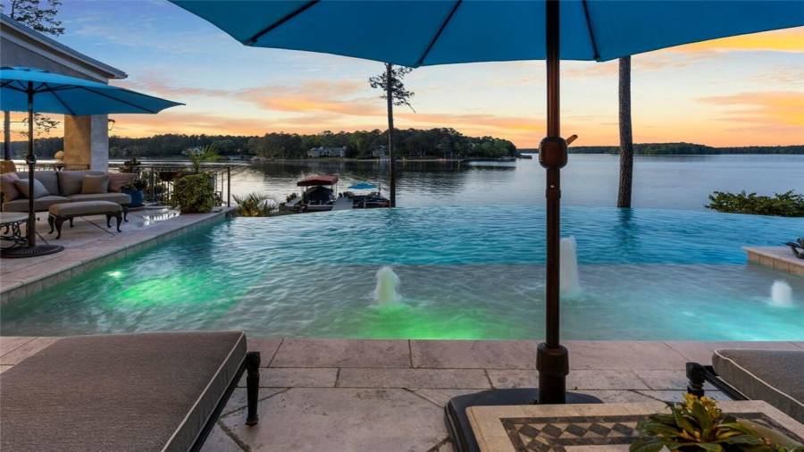 Salt water infinity edge pool flows over to stunning views of the lake.