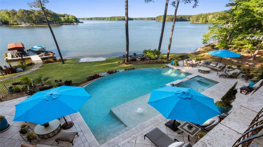 Upstairs outdoor living area overlooks the infinity pool and lakefront entertaining spaces.