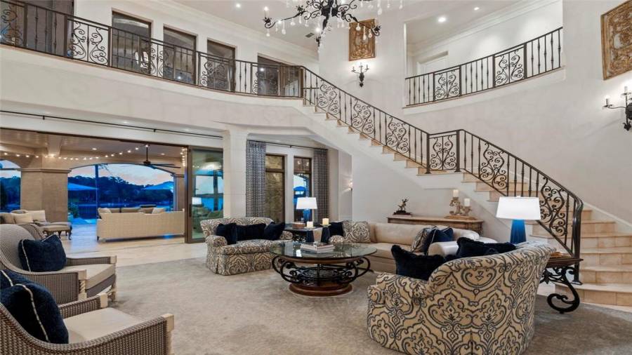 Custom iron work staircase wraps around the living room.