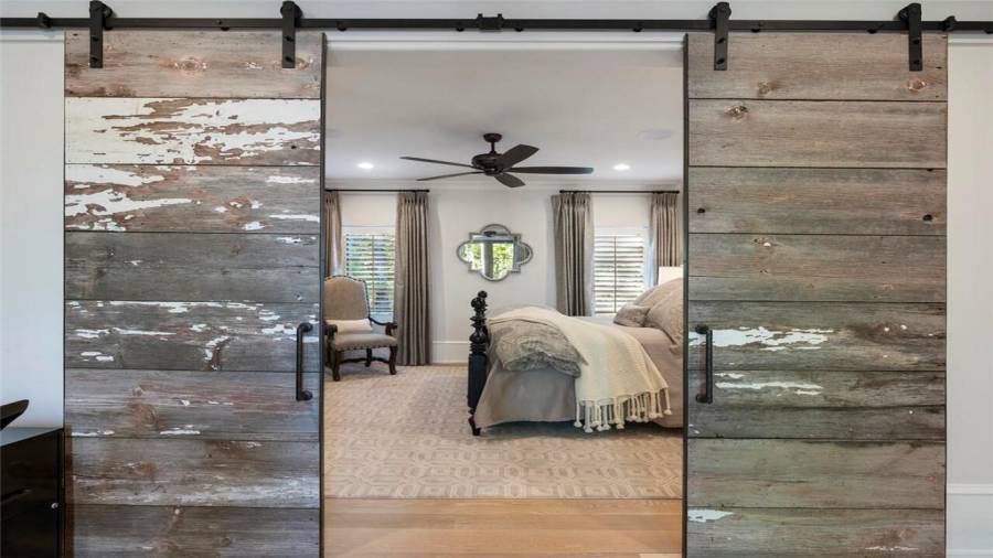 Wooden barn doors open to the bedroom of the carriage apartment.