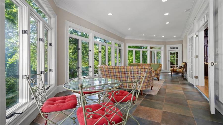 Lovely sunroom with incredible windows - opens to the family/great room, the kitchen and the owners suite.