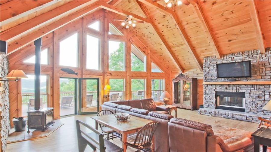 The Great Room is highlighted by this spectacular wall of windows which frames the long range views of the North Georgia mountains. Not only is there a stacked-stone see-through fireplace in the Great Room, there is a wood burning stove also.