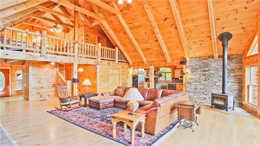 The stacked stone wall behind the wood stove gives the room a rustic feel.