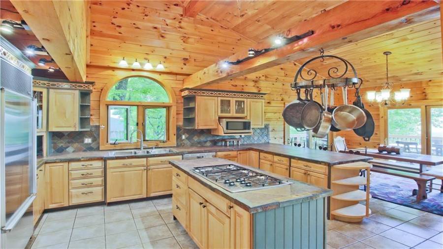 The beautiful kitchen has a breakfast bar, an island with a gas cook top, a new Kitchen Aide dishwasher, lots of cabinet storage, lots of counter space, and is open to the Dining Room and the Great Room.