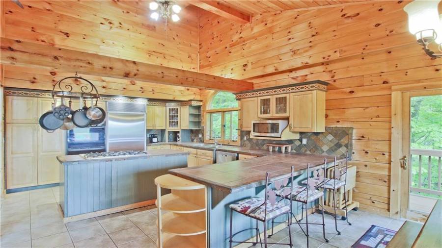 The beautiful kitchen has a breakfast bar, an island with a gas cook top, a new Kitchen Aide dishwasher, lots of cabinet storage, lots of counter space, and is open to the Dining Room and the Great Room.