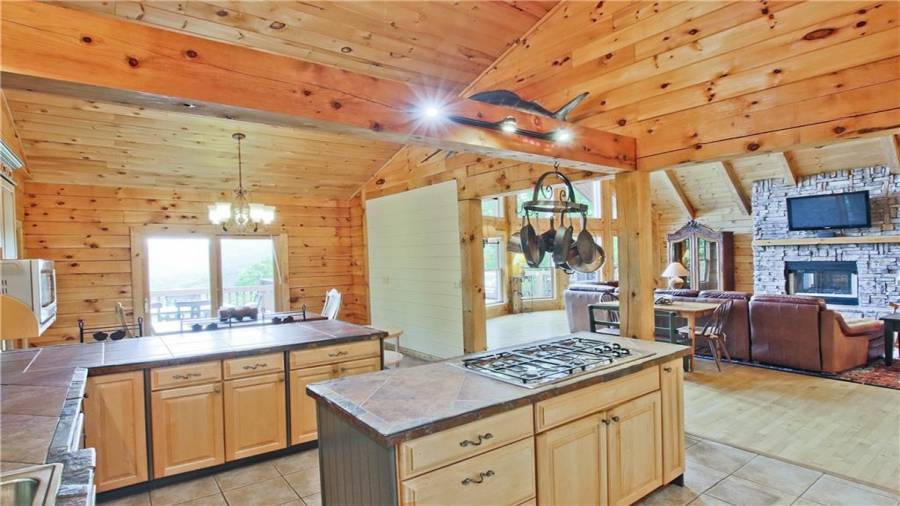 The beautiful kitchen has a breakfast bar, an island with a gas cook top, a new Kitchen Aide dishwasher, lots of cabinet storage, lots of counter space, and is open to the Dining Room and the Great Room.