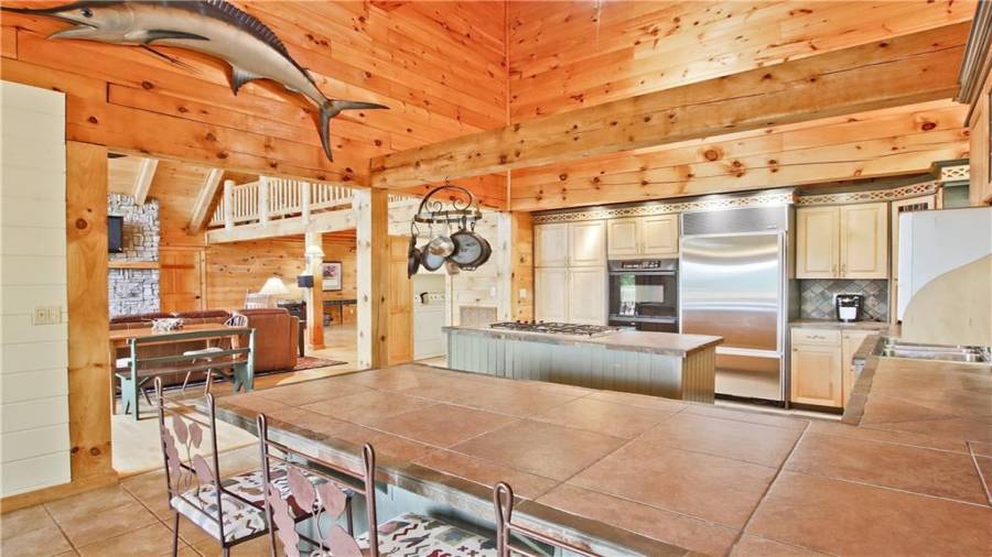 The beautiful kitchen has a breakfast bar, an island with a gas cook top, a new Kitchen Aide dishwasher, lots of cabinet storage, lots of counter space, and is open to the Dining Room and the Great Room.