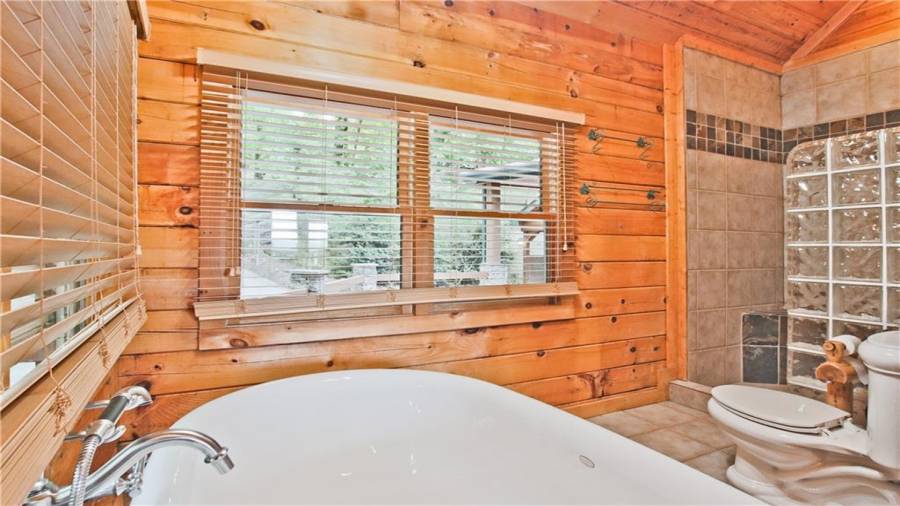 The spacious walk-in shower has tiled walls with glass block accents.