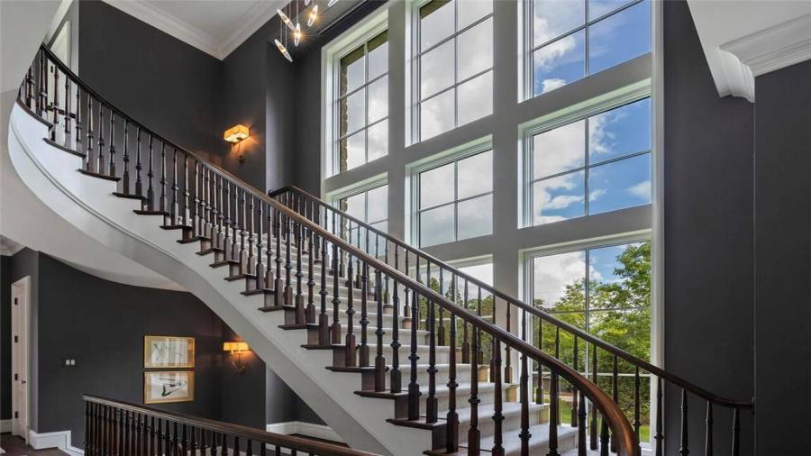 Wall of windows allows sunlight to flood the staircase and entryway.