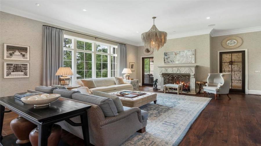 Door out to a covered patio with fireplace and grilling area.