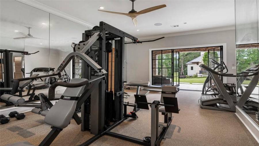 Gym with iron doors opening to the pool and patio.