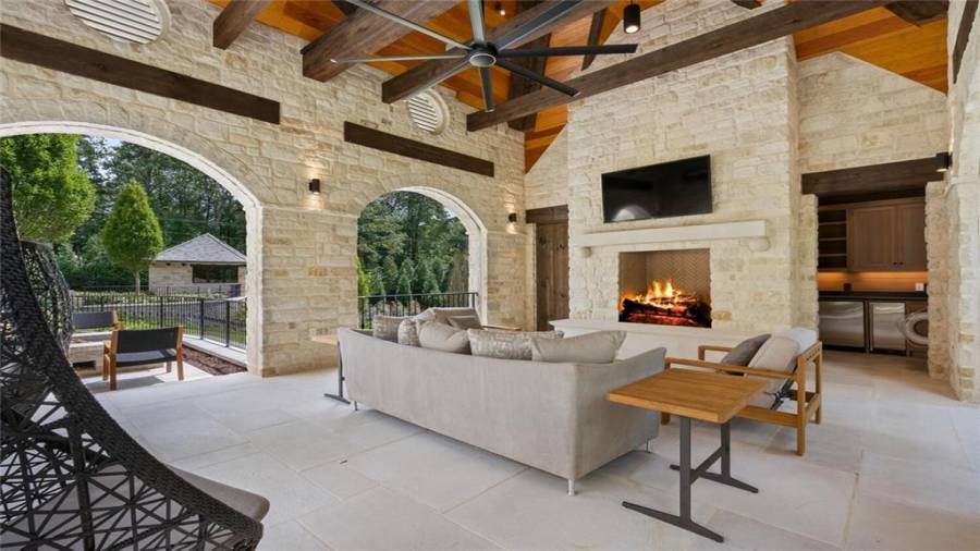Stone and slate pool house with motorized screens, kitchen, half bath and office space below. Fireplace and firepit.