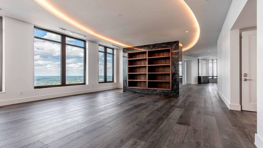 Living Room with Floating Wall and Bookshelves Wrapped in Natural Stone.