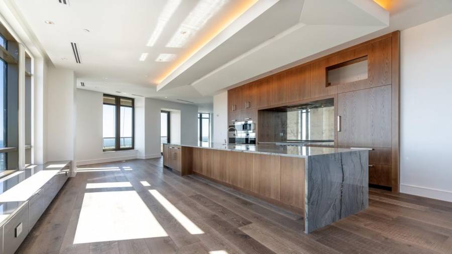 Kitchen with Waterfall Edge Stone Countertops and Walnut Cabinets.