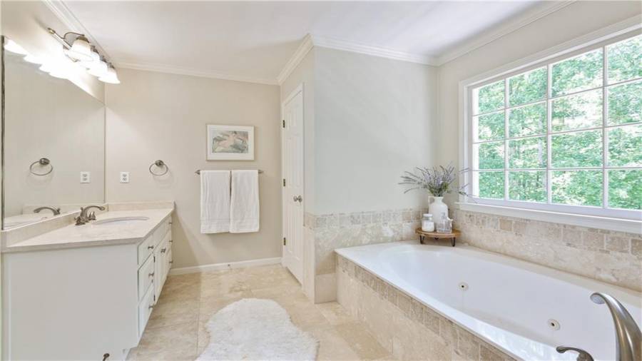 Oversized jetted tub, dual vanities and tiled walk-in shower in the primary bath.
