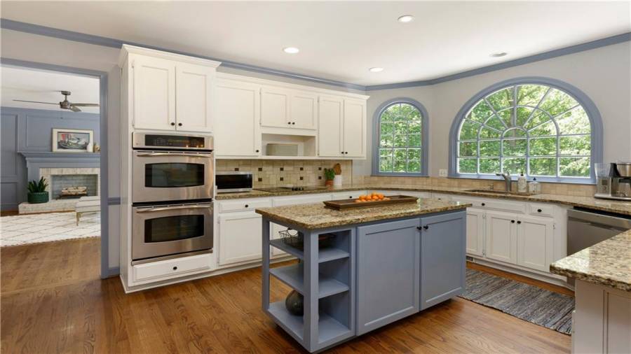 Updated eat-in kitchen with granite countertops, tiled backsplash, double ovens and custom cabinetry.
