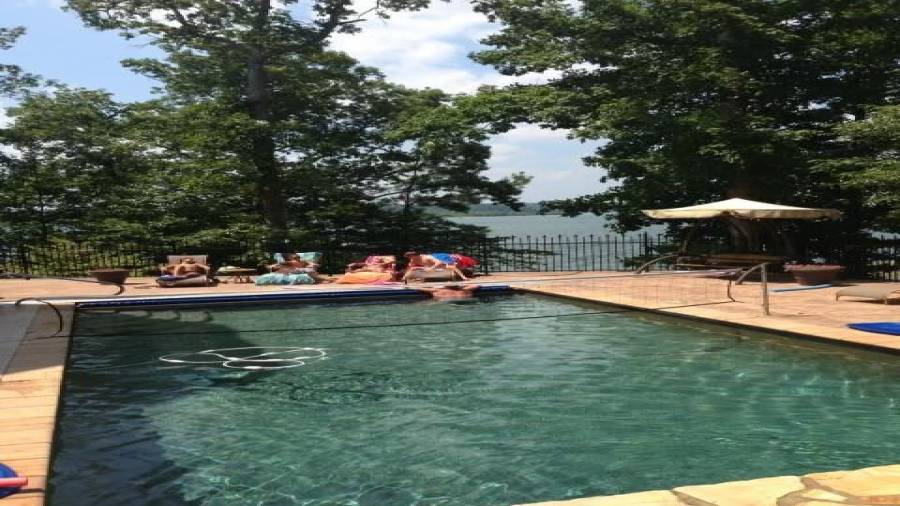 Just imagine all the fun you and your family and friends will have in the outdoor area. Salt water inground gunite pool, hot tub w/waterfall and a fire pit in case you get cold. Lush landscaping is manicured and offers plenty of privacy.  You can see the lake and the mountains in the background.