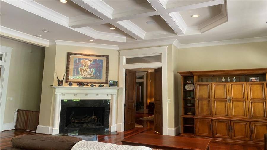 Family room is open and spacious. This fireplace will keep you warm in the winter. You can tell the attention to every detail in all the trim in the home. Coffered ceilings through out the living area, kitchen and dining area. Book cases stay with the home. All doors are solid wood. If you are impressed with the photos your not going to believe it in person. Most amazing home.