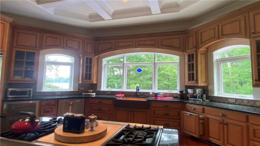 Kitchens custom built cabinets are absolutely gorgeous. The arched bay window in the kitchen overlooks lake and pool. You would be amazed to see how close you are to the water. Dishwasher, wine rack and the trash can is built into the cabinet!