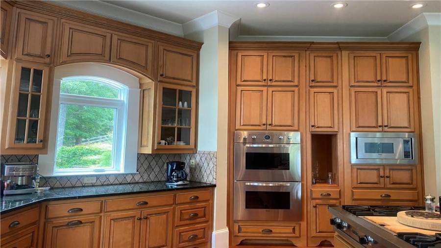 Chef in the family will love this open kitchen, with plenty of storage space. Stainless steel appliances features Viking double ovens, microwave. Kitchen features granite counter tops tiled back splash. Windows overlooking pool entertaining area and lake views.