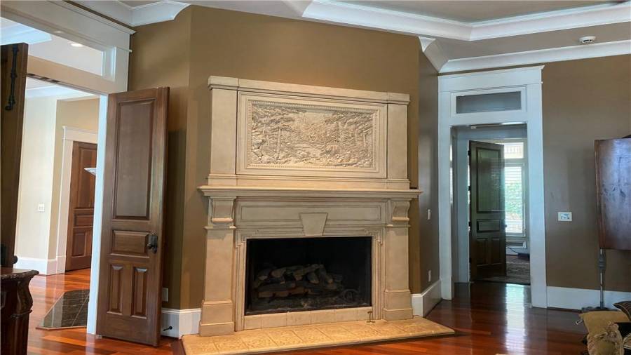 Custom designed fireplace in the mast suite with gas logs. Solid wood doors. Office on the main level is to the right of the fireplace. Custom detail in the top of the fireplace. Must see to appreciate all the custom wood work in this home. You will love it. Nothing like it on the lake.