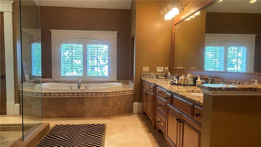 Master bath features double vanity, soaking tub, heated bathroom floors, extra large shower and custom cabinets.