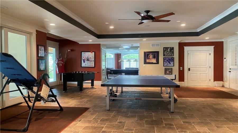 Middle area on the terrace level offers ping pong table, and other games. Large room with tiled floor, trey ceiling with recessed lighting.
