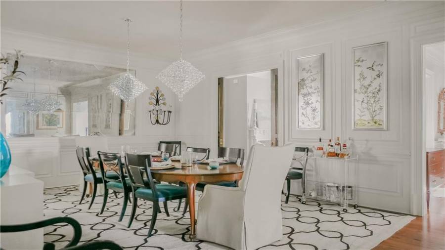 Dining room has unique trim and statement pendant light fixtures.