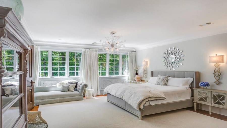 Upper level primary bedroom with casement windows, beautiful sconces and statement light fixture.