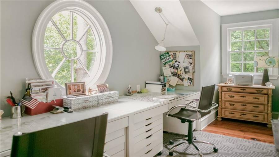 Private upstairs home office off primary suite has lots of light from East and South facing windows.