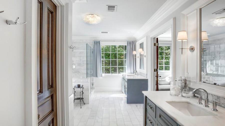 Master bath is exquisitely appointed with marble and nickel fixtures and sconces.