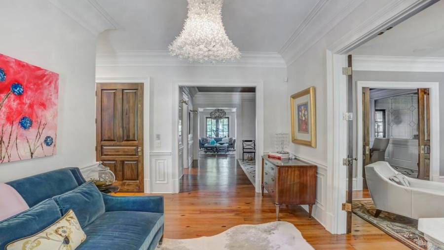 View from front door .. beautiful axis to central French door in family room. Study on the right. Statement light fixture.