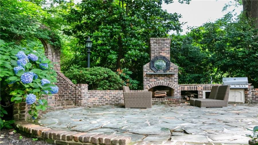 Back stone patio with wood burning fireplace and outdoor kitchen.