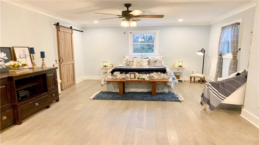 Lovely master bedroom has wood floors and barn door to laundry room...so convenient!