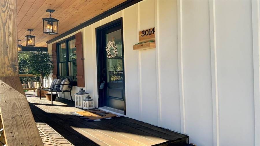 Extra-long front porch with 3 hanging lanterns & 6’ wide entry stairs.  Custom-made address plaque with plant holder.