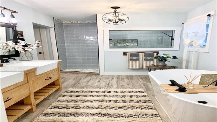 Double farmhouse sink vanity and enormous walk-in shower with custom glass insert & rainshower head.